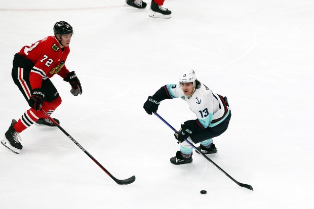 Kraken left wing Brandon Tanev (13) advances the puck as Blackhawks defenseman Alex Vlasic (72) defends in the second period at the United Center in Chicago on Dec. 19, 2024. (Terrence Antonio James/Chicago Tribune)