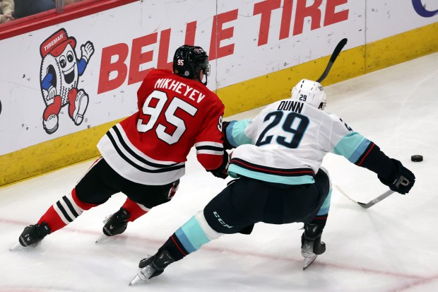 Blackhawks right wing Ilya Mikheyev (95) and Kraken defenseman Vince Dunn (29) chase the puck in the third period at the United Center in Chicago on Dec. 19, 2024. (Terrence Antonio James/Chicago Tribune)