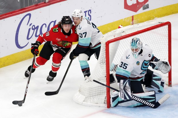 Blackhawks left wing Tyler Bertuzzi (59) puts pressure on Kraken goaltender Joey Daccord (35) as Kraken center Yanni Gourde (37) defends in the third period at the United Center in Chicago on Dec. 19, 2024. (Terrence Antonio James/Chicago Tribune)