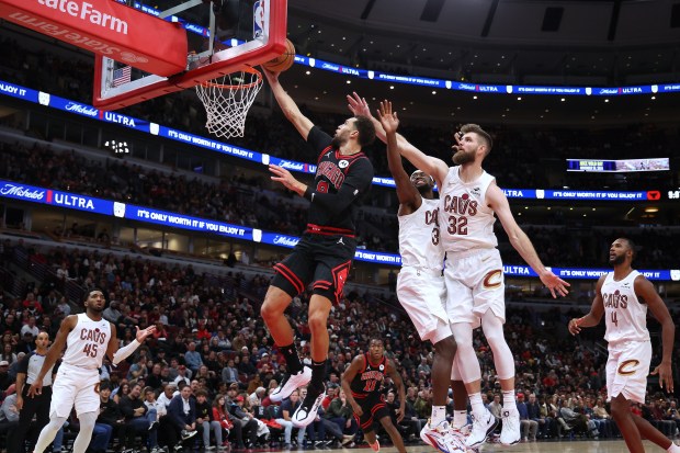 Bulls guard Zach LaVine (8) soars to the basket as Cavaliers guard Caris LeVert (3) and Cavaliers forward Dean Wade (32) defend in the second half at the United Center on Monday, Nov. 11, 2024. The Cavaliers won 119-113. (Terrence Antonio James/Chicago Tribune)