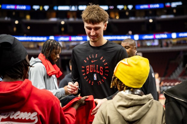 Chicago Bulls forward Matas Buzelis (14), center, autographs shirts before a game against the Minnesota Timberwolves at the United Center on Nov. 7, 2024. (Tess Crowley/Chicago Tribune)