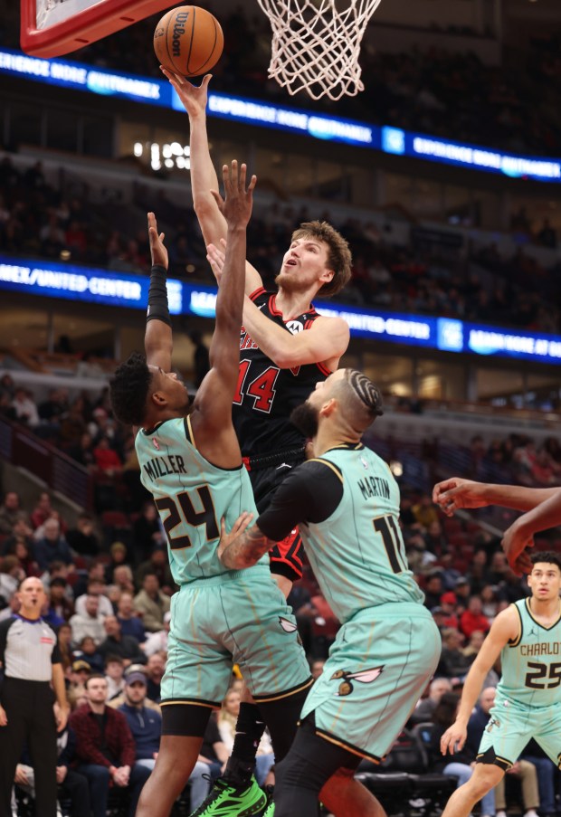 Bulls forward Matas Buzelis (14) rises for a layup as Hornets forward Brandon Miller (24) defends in the first quarter at the United Center on Dec. 13, 2024, in Chicago. (John J. Kim/Chicago Tribune)