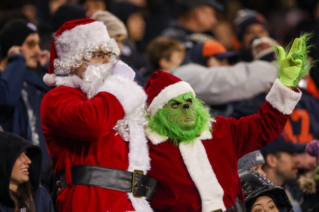 Fans dressed as Santa Claus and the Grinch watch the Chicago Bears play the Seattle Seahawks during the second quarter at Soldier Field on Dec. 26, 2024. (Armando L. Sanchez/Chicago Tribune)