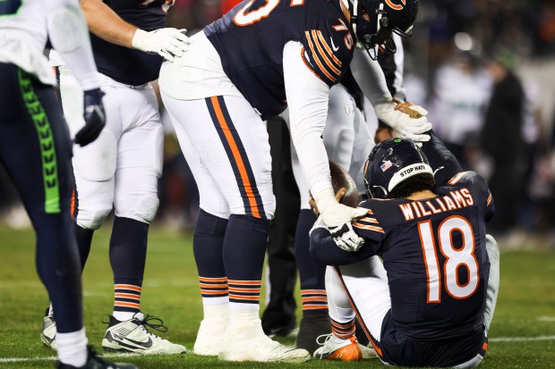 Chicago Bears quarterback Caleb Williams (18) is helped up after being sacked during the third quarter against the Seattle Seahawks at Soldier Field on Thursday, Dec. 26, 2024. (Eileen T. Meslar/Chicago Tribune)