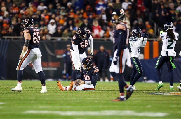 Chicago Bears offensive tackle Darnell Wright (58) helps Chicago Bears quarterback Caleb Williams (18) up after he was sacked during the fourth quarter against the Seattle Seahawks at Soldier Field on Thursday, Dec. 26, 2024. (Eileen T. Meslar/Chicago Tribune)