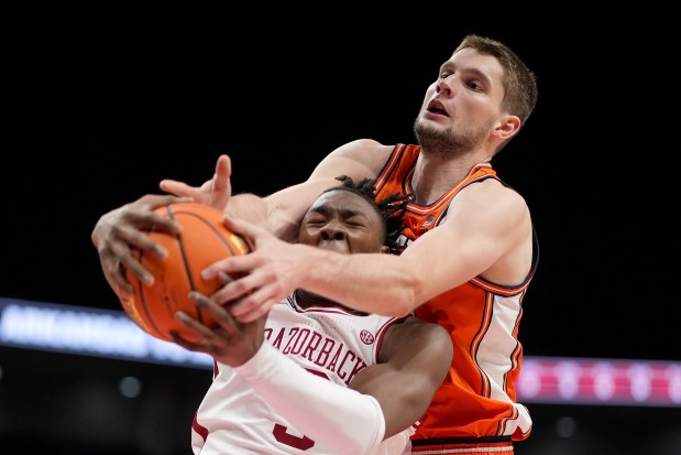 Arkansas forward Adou Thiero, front, and Illinois center Tomislav Ivisic battle for a rebound on Nov. 28, 2024, in Kansas City, Mo. (AP Photo/Charlie Riedel)