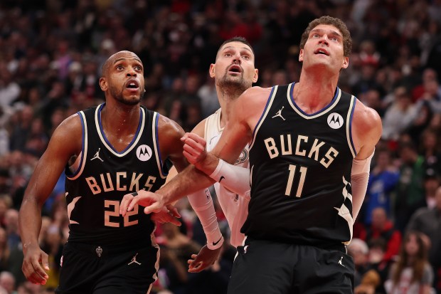 Khris Middleton (22) and Brook Lopez (11) of the Bucks battle with Bulls center Nikola Vucevic for position during the second half on Dec. 28, 2024, at the United Center. (Michael Reaves/Getty Images)