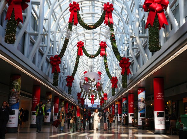 Travelers walk through a grandly decorated terminal at Chicago O'Hare International Airport on Dec. 3, 2024, in Chicago. (Stacey Wescott/ Chicago Tribune)