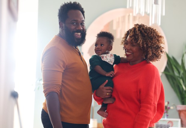 McKenzie Chinn, right, along with her partner Mykele Deville and their seven-month-old son, Ocean, at their home in the Bronzeville neighborhood of Chicago on Dec. 9, 2024. (Stacey Wescott/Chicago Tribune)