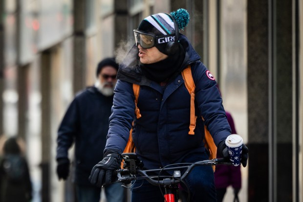 A person bikes on Grand Ave. during cold temperatures in Chicago on Nov. 30, 2024. (Tess Crowley/Chicago Tribune)