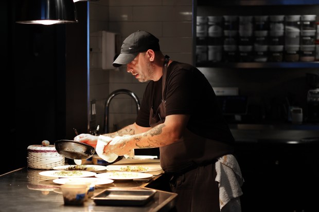 Chef and owner Norman Fenton finishes plating orders in his restaurant Cariño on Aug. 29, 2024. (Terrence Antonio James/Chicago Tribune)