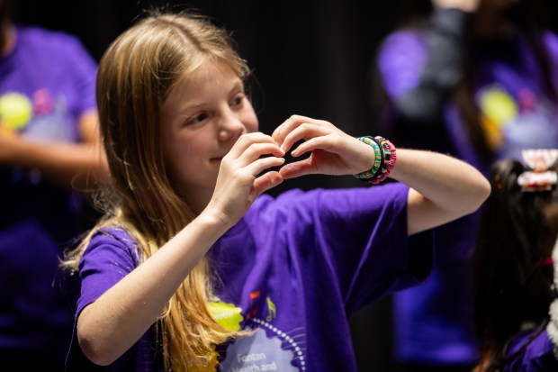 Alex Weil, 11, patient in Lurie Children's Single Ventricle Center of Excellence, makes a heart for the audience after performing in the Fontan Choir at Northwestern University's Bienen School of Music in Evanston on Dec. 4, 2024. (Tess Crowley/Chicago Tribune)