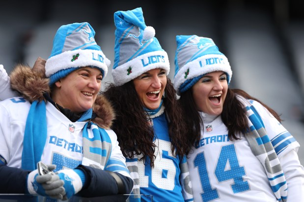 Detroit Lions fans pose for a photograph in the stands as players warm up for a game between the Lions and the Chicago Bears at Soldier Field. (Chris Sweda/Chicago Tribune)