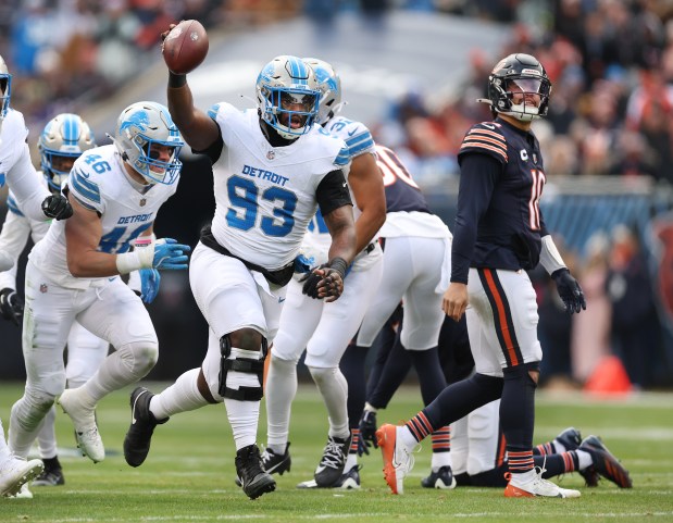 Detroit Lions defensive end Josh Paschal celebrates after recovering a fumble as Bears quarterback Caleb William, right, walks off the field in the first quarter at Soldier Field. (Chris Sweda/Chicago Tribune)