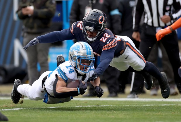 Chicago Bears safety Elijah Hicks (22) tackles Detroit Lions wide receiver Amon-Ra St. Brown (14) in the first quarter of a game at Soldier Field in Chicago on Dec. 22, 2024. (Chris Sweda/Chicago Tribune)