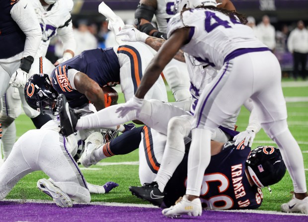 Bears center Doug Kramer Jr. (lower right) commits a penalty as running back D'Andre Swift crosses the goal line in the third quarter against the Minnesota Vikings at U.S. Bank Stadium on Dec. 16, 2024. The penalty negated the touchdown by Swift. (Chris Sweda/Chicago Tribune)