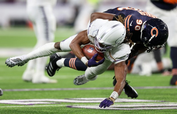 Bears defensive end Dominique Robinson tackles Vikings running back Aaron Jones in the third quarter at U.S. Bank Stadium in Minneapolis on Dec. 16, 2024. (Chris Sweda/Chicago Tribune)