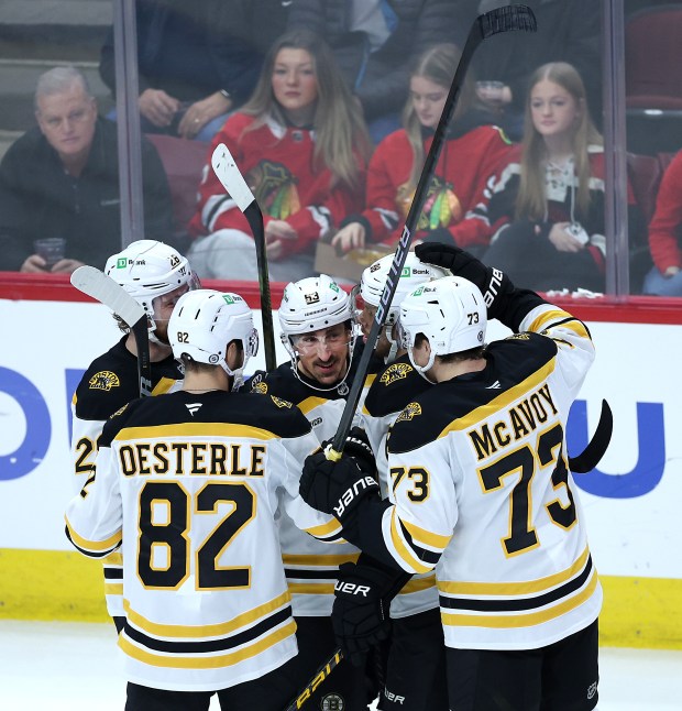 Bruins left wing Brad Marchand (center) celebrates with his teammates after scoring a goal in the second period against the Blackhawks at the United Center on Dec. 4, 2024. (Chris Sweda/Chicago Tribune)