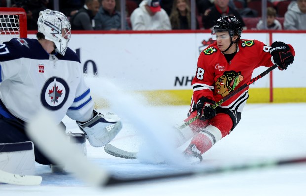 Chicago Blackhawks center Connor Bedard (98) stops his momentum as he looks for a pass while trying to score on Winnipeg Jets goaltender Connor Hellebuyck (37) in the first period of a game at the United Center in Chicago on Dec. 7, 2024. (Chris Sweda/Chicago Tribune)