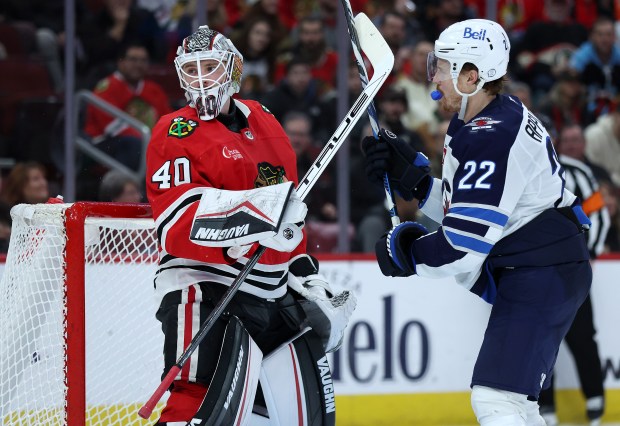 Chicago Blackhawks goaltender Arvid Soderblom (40) and Winnipeg Jets center Mason Appleton (22) lock hockey sticks in the second period of a game at the United Center in Chicago on Dec. 7, 2024. (Chris Sweda/Chicago Tribune)