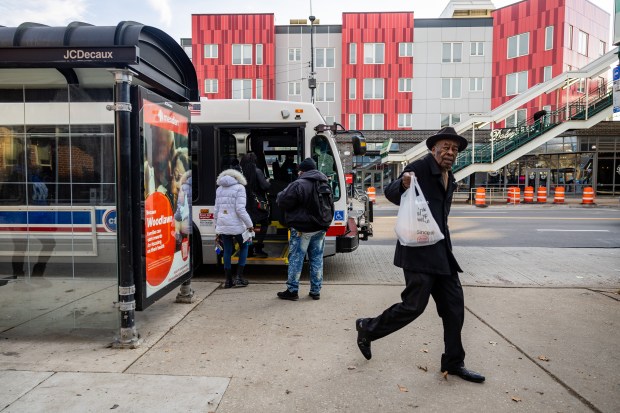 People enter and exit the CTA #4 bus at East 63rd Street & South Cottage Grove Avenue in Chicago's Woodlawn neighborhood on Dec. 10, 2024. (Tess Crowley/Chicago Tribune)