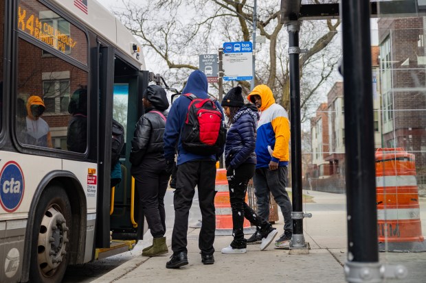 People ride the #4 CTA bus at East 63rd Street & South Cottage Grove Avenue in the Woodlawn neighborhood on Dec. 10, 2024. (Tess Crowley/Chicago Tribune)