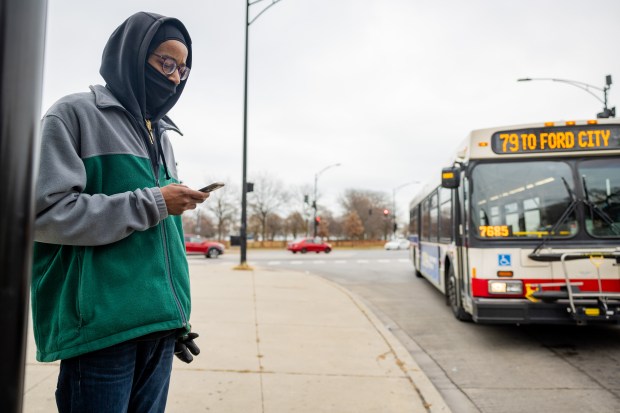 Timothy Porter waits for the CTA #79 bus at South Shore Drive and East 79th Street in Chicago on Dec. 10, 2024. (Tess Crowley/Chicago Tribune)