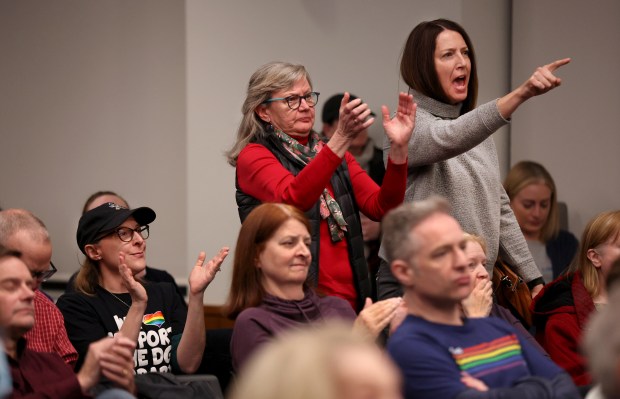 Downers Grove residents show support for Commissioner Leslie Sadowski-Fugitt as she speaks about a proposed nonbinding referendum on the village's public library during a Village Council meeting on Dec. 3, 2024. (Chris Sweda/Chicago Tribune)