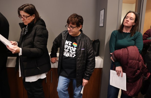 Downers Grove resident Lisa Scott, center, listens as the topic of a proposed nonbonding referendum about the village's public library is discussed during a regular village council meeting on Dec. 3, 2024. (Chris Sweda/Chicago Tribune)