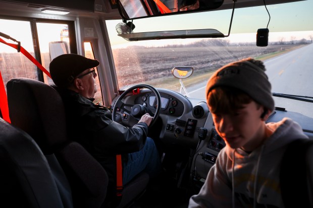 Herscher School District bus driver Chris Hadley greets a student as he picks him up for school in an electric school bus in Kankakee County on Tuesday, Dec. 17, 2024. (Eileen T. Meslar/Chicago Tribune)