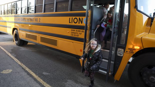 Herscher school district students get off the electric school bus at their school in Kankakee County on Dec. 17, 2024. (Eileen T. Meslar/Chicago Tribune)