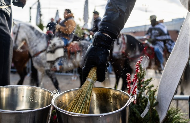 Hoseback riders from Club Los Vaqueros Unidos are sprayed with holy water at the shrine as they finish the pilgrimage to the Shrine of Our Lady of Guadalupe in Des Plaines on Dec. 7, 2024. (Tess Crowley/Chicago Tribune)