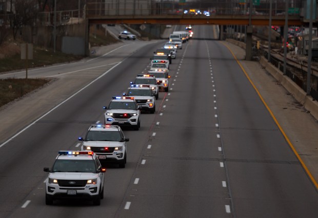 A procession of Oak Park police vehicles travel down the Eisenhower Expressway, Dec. 12, 2024, enroute to the funeral of Detective Allan Reddins who was shot and killed Nov.. (Stacey Wescott/Chicago Tribune)