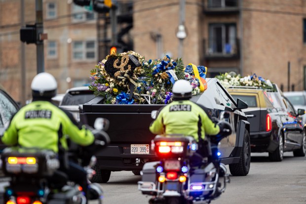 Evanston police officers ride in a procession following the funeral service for Oak Park police Detective Allan Reddins at Apostolic Church of God in the Woodlawn neighborhood of Chicago on Dec. 12, 2024. (Tess Crowley/Chicago Tribune)