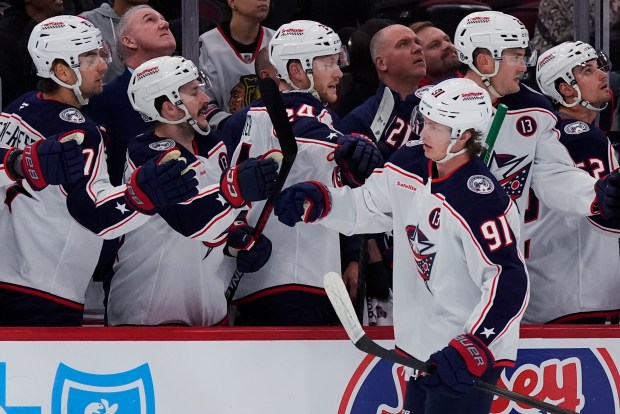 Columbus Blue Jackets center Kent Johnson (91) celebrates with teammates after scoring during the first period of an NHL hockey game against the Chicago Blackhawks in Chicago, Sunday, Dec.1, 2024. (AP Photo/Nam Y. Huh)