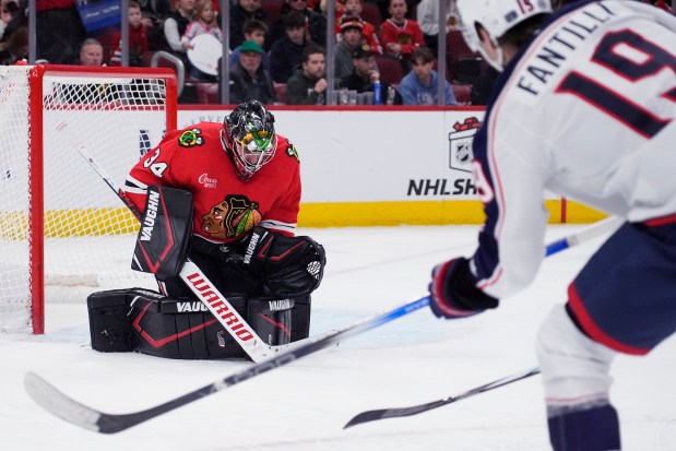 Chicago Blackhawks goaltender Petr Mrazek, left, saves a shot by Columbus Blue Jackets center Adam Fantilli during the second period of an NHL hockey game in Chicago, Sunday, Dec.1, 2024. (AP Photo/Nam Y. Huh)