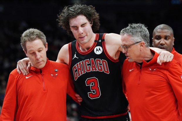 Chicago Bulls' Josh Giddey (3) is helped off the court by medical staff during the second half of an NBA basketball game against the Toronto Raptors in Toronto on Monday, Dec. 16, 2024. (Frank Gunn/The Canadian Press via AP)