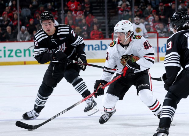 Hawks center Frank Nazar tries to get past the Devils' Timo Meier, left, and Luke Hughes during the third period on Dec. 14, 2024, at Prudential Center in Newark, N.J. (Elsa/Getty)