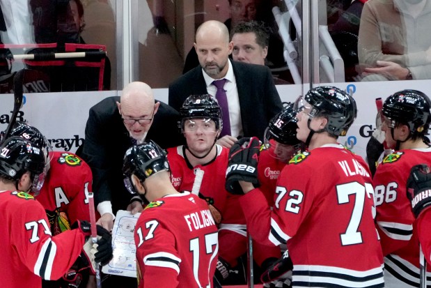 Chicago Blackhawks interim head coach Anders Sorensen, top right, listens as assistant coach Derek King draws up a play in the closing minutes of an NHL hockey game against the Winnipeg Jets on Saturday, Dec. 7, 2024, in Chicago. The Jets won 4-2. (AP Photo/Charles Rex Arbogast)