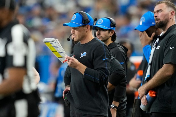 Lions offensive coordinator Ben Johnson looks at his play sheet from the sideline on Dec. 6, 2024, in Detroit. (Carlos Osorio/AP)