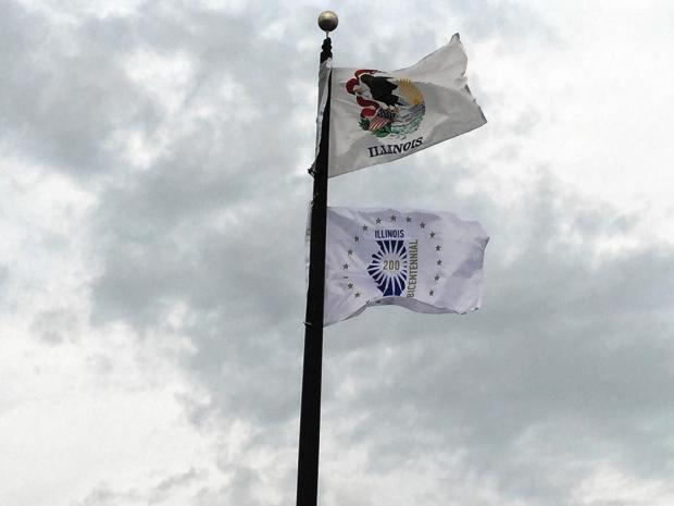 Illinois' new bicentennial flag flies below the state flag in front of the Will County administration building, following a brief ceremony Dec. 4, 2017..