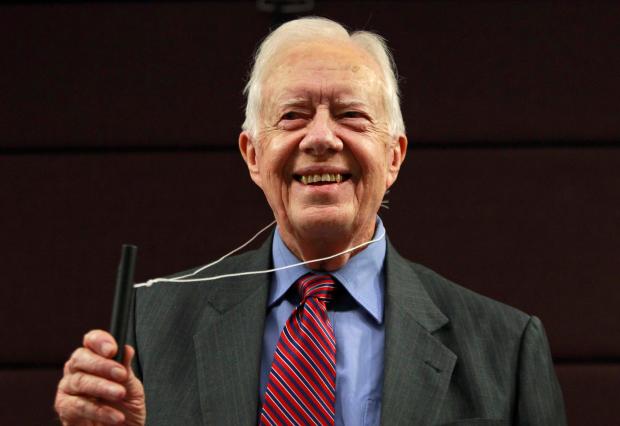 FILE - Former U.S. President Jimmy Carter poses for photographers with a water pipe filter, that is used to combat guinea worm disease, during a news conference to mark the launch of a campaign to eradicate the disease in central London, Wednesday, Oct. 5, 2011. (AP Photo/Lefteris Pitarakis, File)