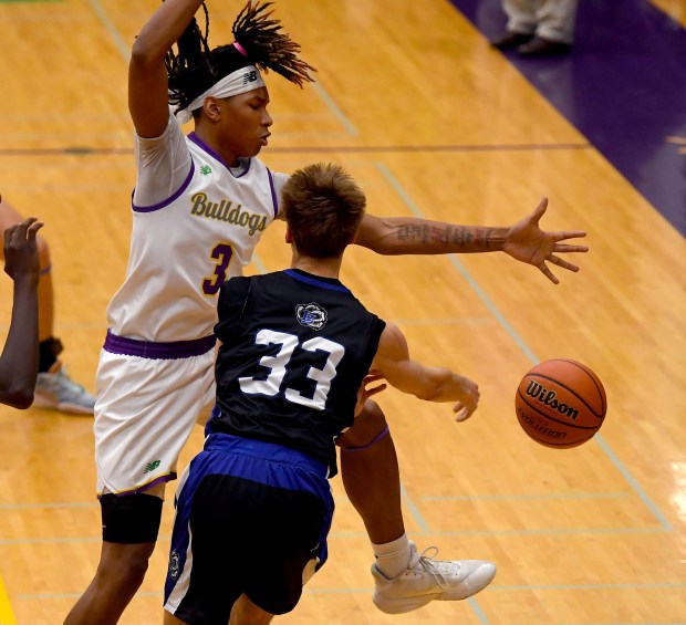 Lake Zurich's Tyler Olson (33) gets the pass off while being covered by Waukegan's Jaali Rico Love (3). Waukegan's boys basketball team defeated Lake Zurich 59-47 in a conference matchup in Waukegan, Wednesday, Dec. 11, 2024 (Rob Dicker / for the News-Sun)