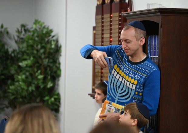 Israel Moskovits of Buffalo Grove, who created menorahs for the Chabad Jewish Center of Vernon Hills, checks out cell phone imagery at the Chabad Jewish Center of Vernon Hills Community Chanukah Celebration on Sunday, Dec. 29, 2024 in Vernon Hills. (Karie Angell Luc/Lake County News-Sun)