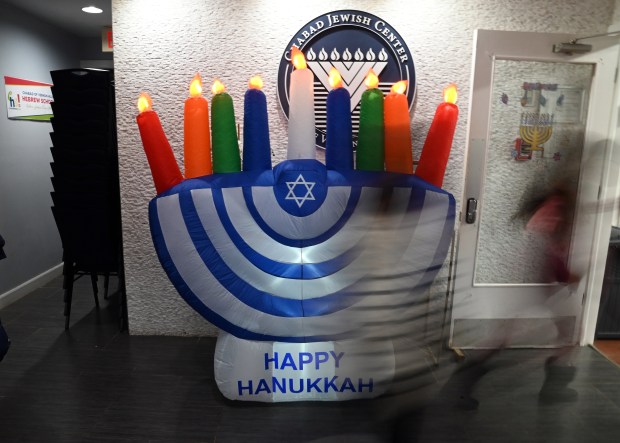 A youngster walks by in an inflatable menorah in the vestibule to enter the party at the Chabad Jewish Center of Vernon Hills Community Chanukah Celebration on Sunday, Dec. 29, 2024 in Vernon Hills. (Karie Angell Luc/Lake County News-Sun)