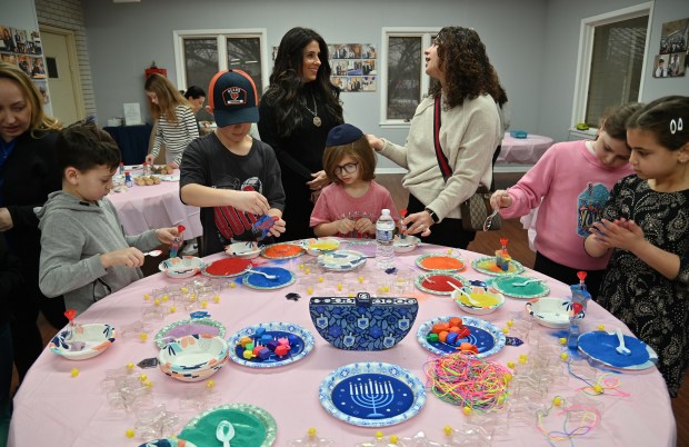 Top, center, from left to right, Rochel Susskind of Vernon Hills, co-director of Chabad Jewish Center of Vernon Hills, talks with Allison Stern of Kildeer at the Chabad Jewish Center of Vernon Hills Community Chanukah Celebration on Sunday, Dec. 29, 2024 in Vernon Hills. (Karie Angell Luc/Lake County News-Sun)