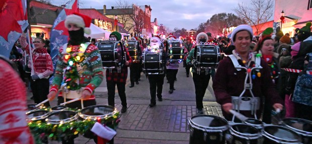 The Grayslake North High School Marching Knights marching band travels with the parade on Center Street at the Festival of Lights and Holiday Market on Nov. 29, 2024 in downtown Grayslake. (Karie Angell Luc/Lake County News-Sun)