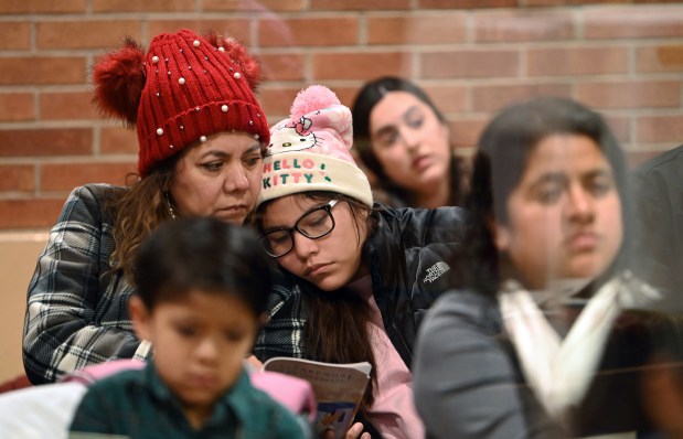 From left, close to each other are grandparent Ofelia Olmedo of Round Lake Beach and grandchild Ruby during mass for Simbang Gabi 2024 on Dec. 21, 2024 at St. Joseph Catholic Church in Round Lake. (Karie Angell Luc/Lake County News-Sun)