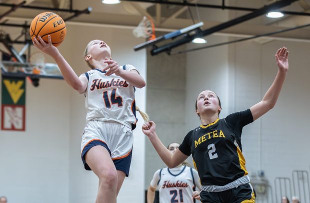 Naperville North's Sydney Smith (14) goes up for a layup against Metea Valley during a DuPage Valley Conference game in Naperville on Thursday, Dec. 19, 2024. (Troy Stolt / for the Naperville Sun)