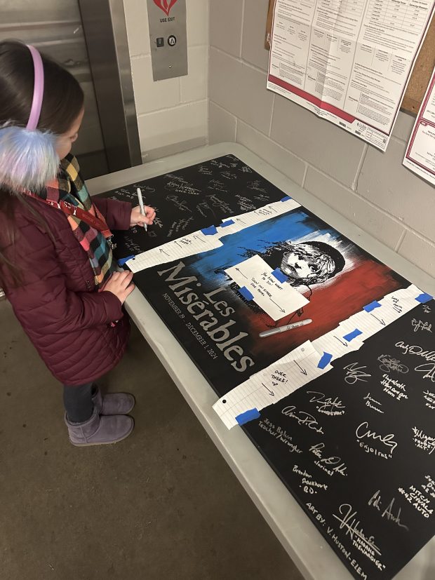 Emmy Chan signs her autograph on a "Les Misérables" poster in Minneapolis, Minnesota. (Lindsay Chan)